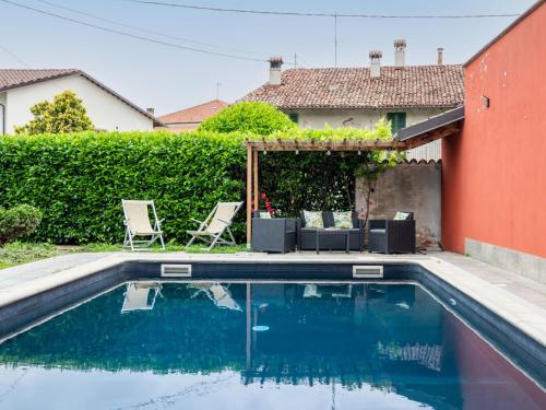 a swimming pool in a yard with chairs and a house at Holiday Home La Grotta di Cech by Interhome in Narzole