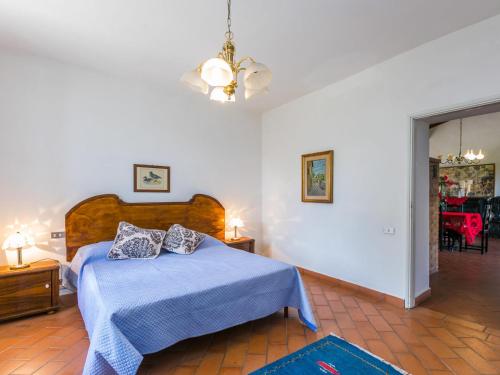 una camera con un letto blu con due cuscini sopra di Apartment Fattoria Petraglia - Padronale by Interhome a Monteriggioni