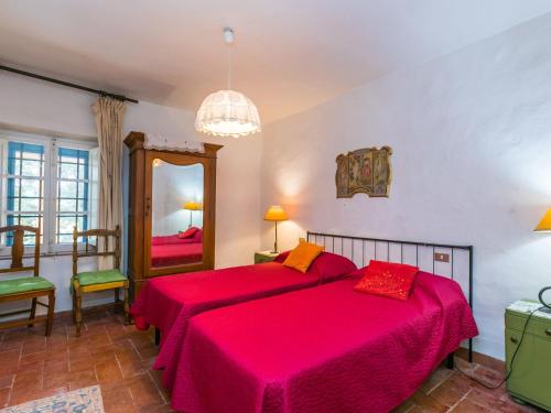 una camera da letto con due letti e uno specchio di Apartment Fattoria Petraglia - Padronale by Interhome a Monteriggioni