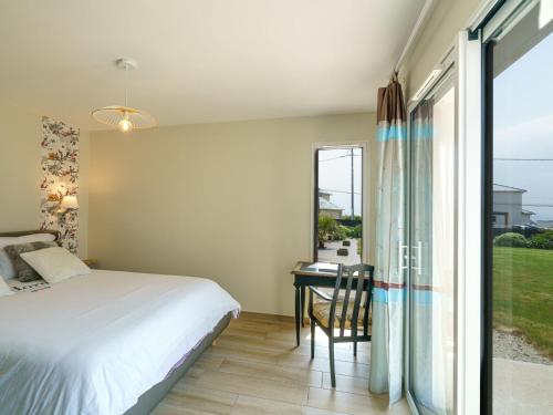 a bedroom with a bed and a desk and a window at Holiday Home Orphée by Interhome in Telgruc-sur-Mer