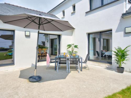 a table with an umbrella in front of a house at Holiday Home Orphée by Interhome in Telgruc-sur-Mer