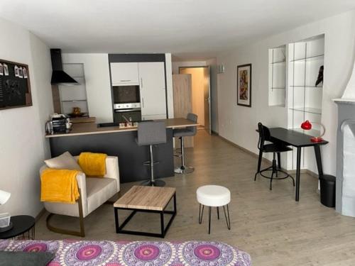 ein Wohnzimmer mit einem Sofa und einem Tisch in der Unterkunft F1 Centre Historique Saint Valbert in Luxeuil-les-Bains