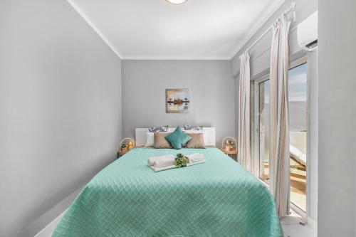 クアルテイラにあるCosy Penthouse Apartment with Large Terrace & Seaviewの白いベッドルーム(緑のベッド、窓付)