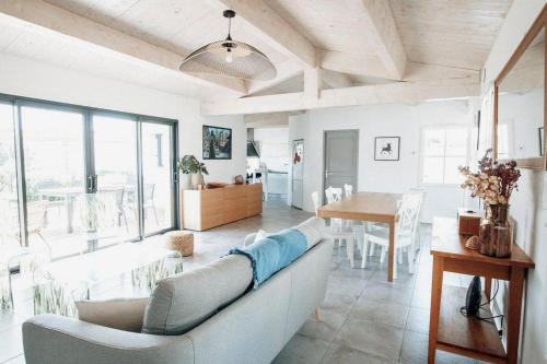 een woonkamer met een bank en een tafel bij Maison 3 chambres plus 1 studio indépendant in Sainte-Marie-de-Ré