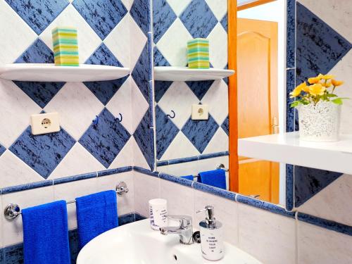 een badkamer met een wastafel en blauwe en witte tegels bij BungaLove Maspalomas in Maspalomas