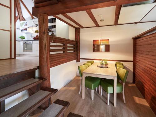 uma sala de jantar com uma mesa e cadeiras verdes em Holiday Home Am Sternberg 4 by Interhome em Frankenau