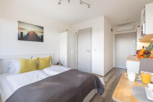 a bedroom with a large bed and a table at Pauzo Balaton in Balatonföldvár