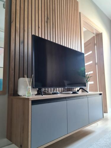a flat screen tv sitting on top of a white cabinet at Mostowa 23 HUGO Apartment, self check-in 24h, free parking, air-conditioning in Poznań