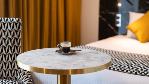 a cup of coffee on a table in a hotel room at Hôtel d'Angleterre Rouen Centre Gare in Rouen
