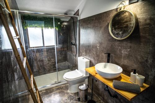 La salle de bains est pourvue de toilettes, d'un lavabo et d'une douche. dans l'établissement House of PAB, à Praia da Areia Branca