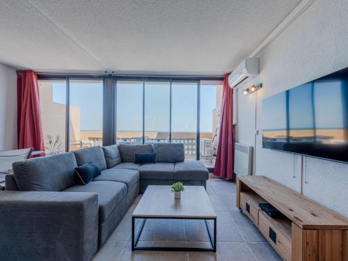 un salon avec un canapé et une télévision dans l'établissement Apartment Les Argonautes-4 by Interhome, au Barcarès