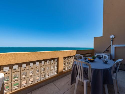 une table et des chaises sur un balcon avec vue sur l'océan dans l'établissement Apartment Les Argonautes-4 by Interhome, au Barcarès