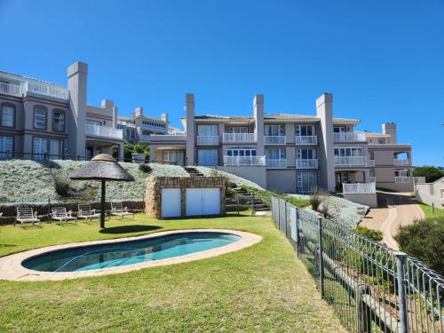 ein Haus mit einem Garten mit Pool und Zaun in der Unterkunft Pinnacle Point Golf Estate - Golf Villa 10-1 in Mossel Bay