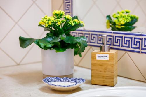 a vase with yellow flowers in it next to a plate at Villa Nobre by The Portuguese Butler in Albufeira