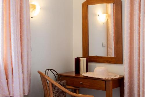 a mirror and a table with a chair and a mirror at Nikiana Club - Studio 5 in Nikiana