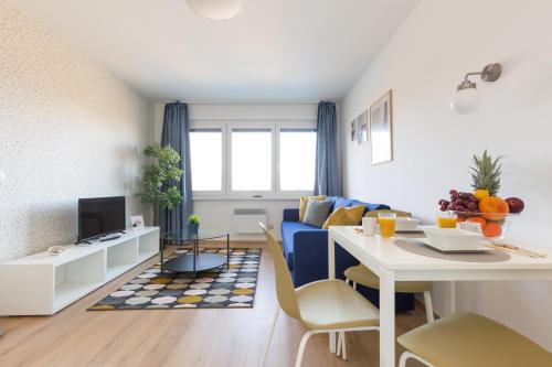 a living room with a blue couch and a table at Pauzo Balaton in Balatonföldvár