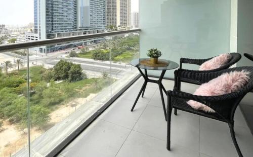 um quarto com uma mesa e cadeiras e uma grande janela em Elegant Studio in park View JVC em Dubai