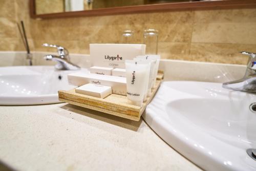 a bathroom counter with two sinks and a tray of toiletries at The Lilygate Lagos in Lagos