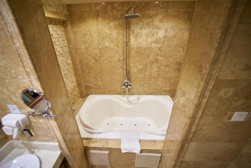 a bathroom with a bath tub and a shower at The Lilygate Lagos in Lagos