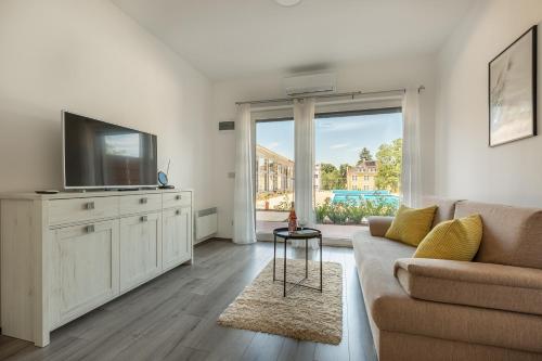 a living room with a couch and a tv at Pauzo Balaton in Balatonföldvár
