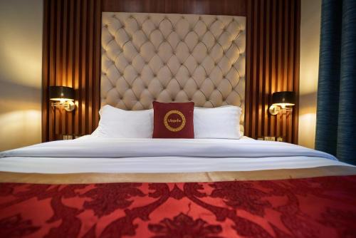 a bedroom with a large bed with a large headboard at The Lilygate Lagos in Lagos