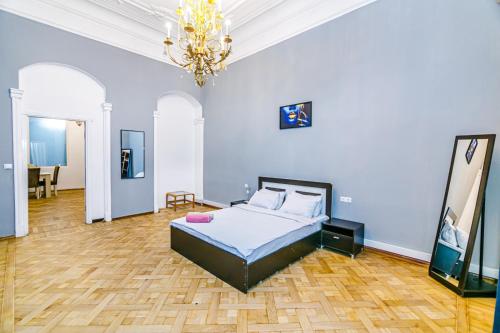 - une chambre avec un lit et un lustre dans l'établissement Apartment Nizami Street 5 room, à Baku