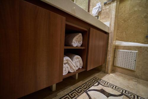 a bathroom with a wooden cabinet with towels at The Lilygate Lagos in Lagos