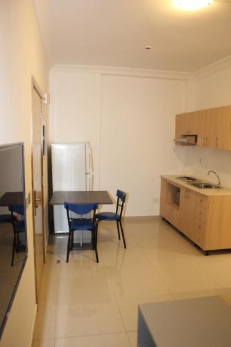 a kitchen with a table and chairs and a refrigerator at Le Caravelle Beirut in Beirut