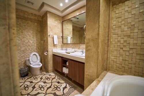 a bathroom with a toilet and a sink and a mirror at The Lilygate Lagos in Lagos