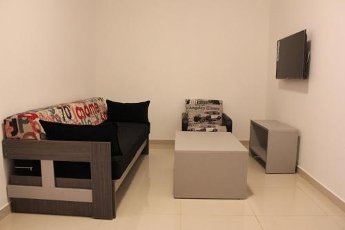 a living room with a couch and a tv at Le Caravelle Beirut in Beirut