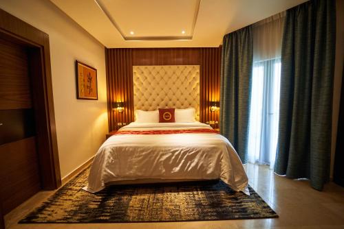 a bedroom with a bed and a large window at The Lilygate Lagos in Lagos