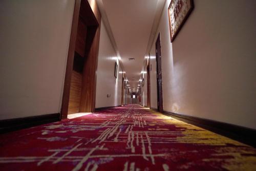 an empty hallway with a red carpet in a building at The Lilygate Lagos in Lagos
