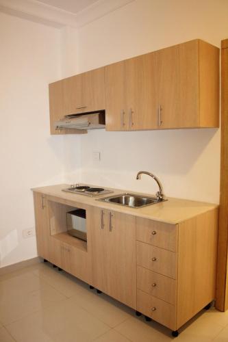 a kitchen with wooden cabinets and a sink at Le Caravelle Beirut in Beirut