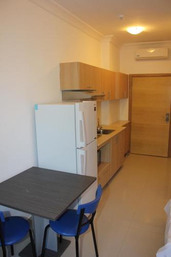 a kitchen with a table and blue chairs and a refrigerator at Le Caravelle Beirut in Beirut