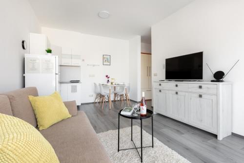 a living room with a couch and a flat screen tv at Pauzo Balaton in Balatonföldvár