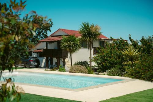 ein Haus mit einem Pool vor einem Haus in der Unterkunft Pura - Home in Nature in Oliveira do Hospital