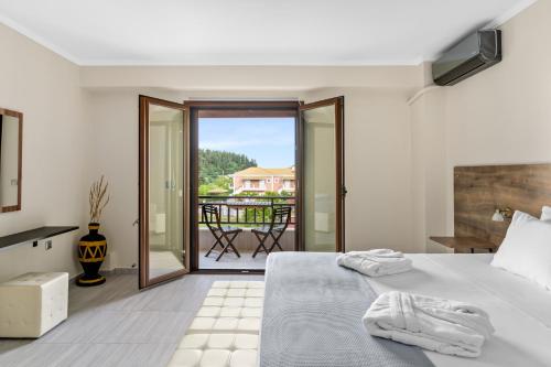 Biała sypialnia z łóżkiem i balkonem w obiekcie The Dandy Villas Sivota w mieście Sivota