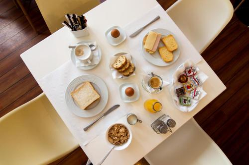 Anemoni Piraeus Hotel في بيرايوس: طاولة بيضاء عليها طعام الإفطار