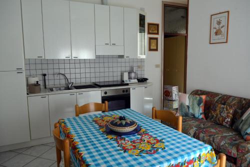 uma cozinha com uma mesa com uma toalha de mesa em Appartamento Climatizzato con Piscina Ca' Aurelia em Lido di Savio