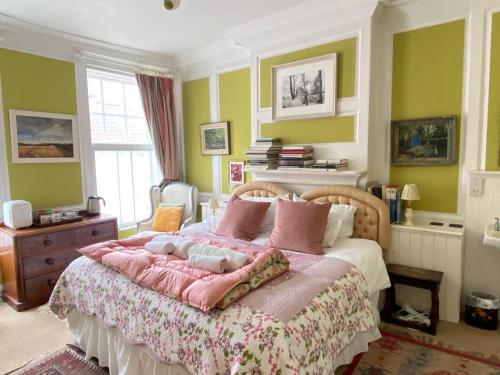1 dormitorio con 1 cama grande con almohadas rosas en The Old Bakehouse, Walsingham, en Little Walsingham