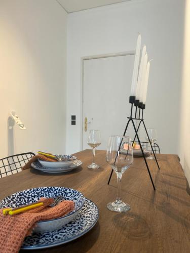 a wooden table with plates and wine glasses on it at Jelinas bright apartment in the centre of Nafplio in Nafplio