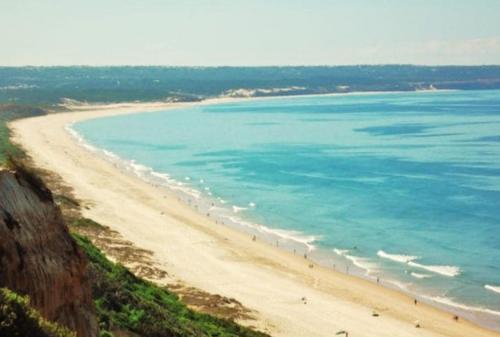 a view of a beach with people in the water at Aroeira House in Aroeira