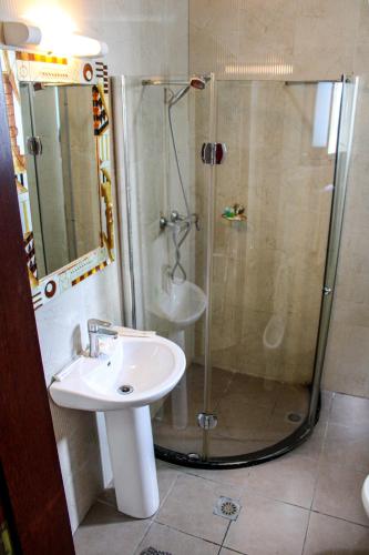 a bathroom with a shower and a sink at Residence Le Carat Bonapriso in Douala