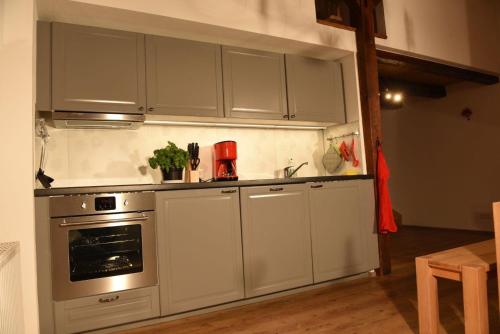 uma cozinha com armários brancos e um forno em Kleines Ferienhaus in Umkirch em Umkirch