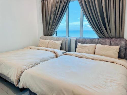 two beds in a room with a window at New l 2BR I 2-6Pax I Jonker 5 Min I SeaView I AmberCove in Melaka
