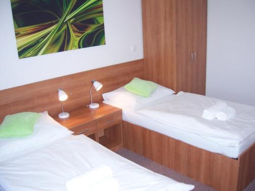 a room with two beds and a desk with two lamps at Penzion Ječmínek in Červená Voda