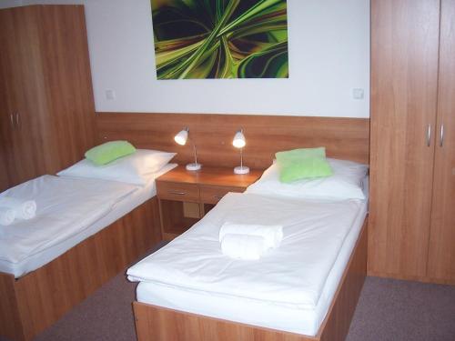 a room with two beds and a desk with lights at Penzion Ječmínek in Červená Voda