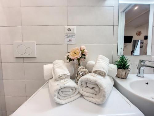 a bathroom with towels and a sink and a mirror at Protea House in Alghero