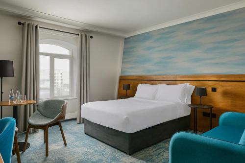 a hotel room with a bed and two chairs at Waterford Marina Hotel in Waterford