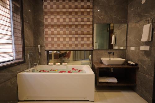 a bathroom with a large tub and a sink at Hotel Taj Crown Plaza - By BS Group Of Hotels in Agra